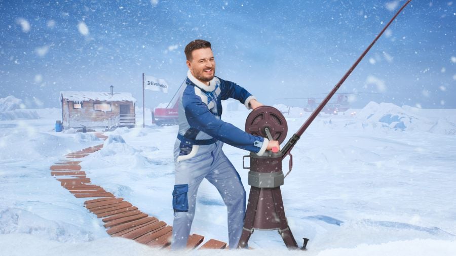 Smiling live game show host in Arctic gear reeling in a fishing rod on a snowy ice fishing set with cabins and helicopters in the background. - partycasino
